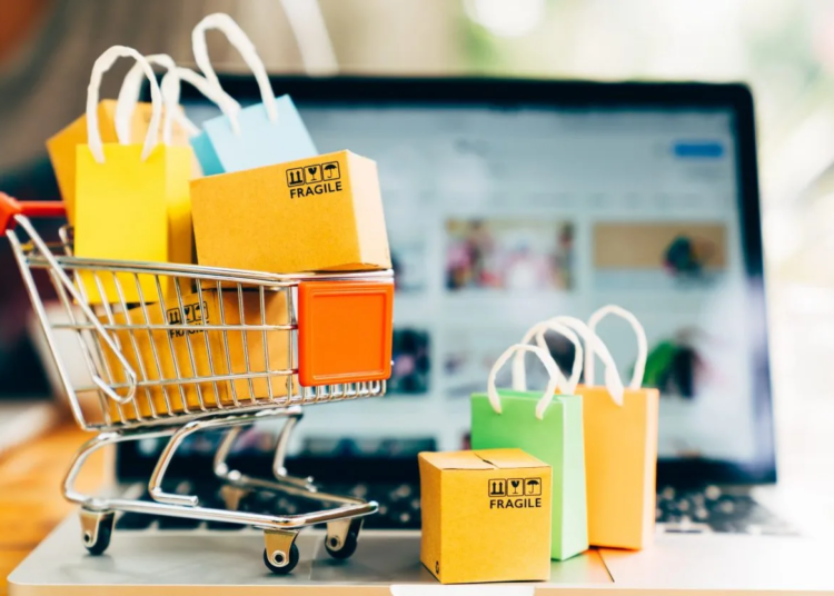 Product package boxes and shopping bag in cart with laptop for online shopping and delivery concept e1652812787531 jpg