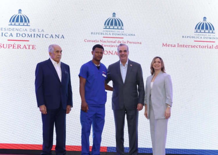 Presidente luis abinader, gloria reyes y el director general de conape, josé garcía ramírez, junto a uno de los hombres que recibieron la certificación oficial como persona cuidadora