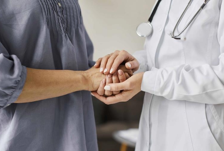 covid recovery center female doctor holding older patient s hands 9ac29c54 focus 0 0 896 504