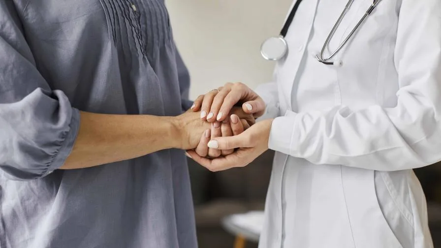 covid recovery center female doctor holding older patient s hands 9ac29c54 focus 0 0 896 504