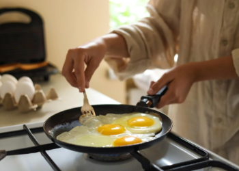 mujer cocinando huevos sabrosos sarten primer plano cocina.jpg