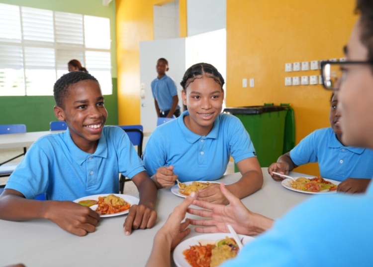 Niños comiendo en un comedor escolar o alimentos saludables en un plato
