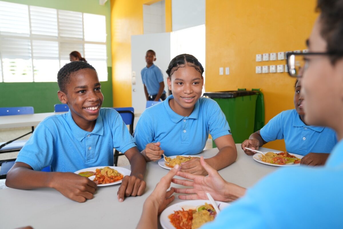 Niños comiendo en un comedor escolar o alimentos saludables en un plato