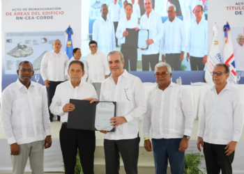 Presidente luis abinader entregando un título de propiedad a una familia dominicana