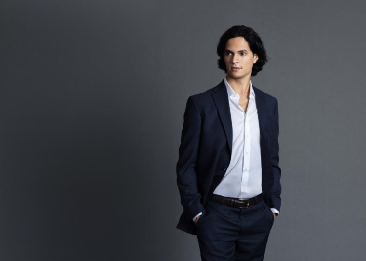 Christopher Sánchez cantando ópera o la fachada del parque Iberoamérica de noche.