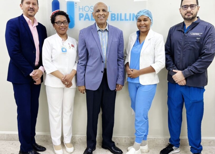 La licenciada Sharlenny Polanco junto al director del Hospital Padre Billini recibiendo un reconocimiento, o un diploma de premio por investigación.