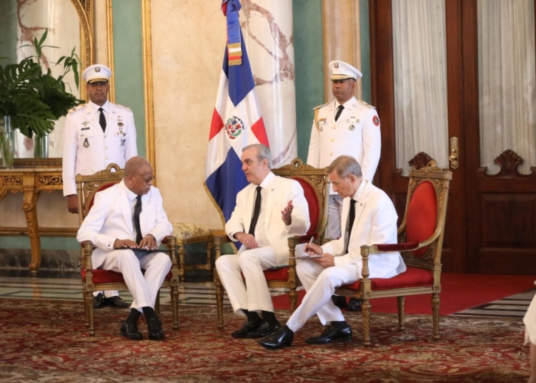 El presidente luis abinader en el palacio nacional recibiendo las cartas credenciales de un embajador, con el ministro roberto álvarez.