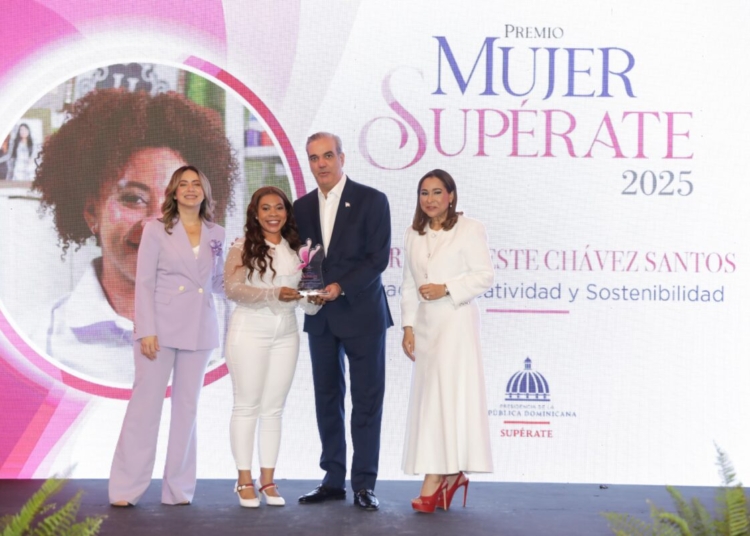 El presidente Luis Abinader en el escenario de los Premios Mujer Supérate, acompañado de mujeres reconocidas, durante la entrega de galardones.