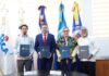 Representantes de Proindustria, JICA, PNUD y Loyola firmando un acuerdo en una mesa, con logos de las instituciones de fondo.