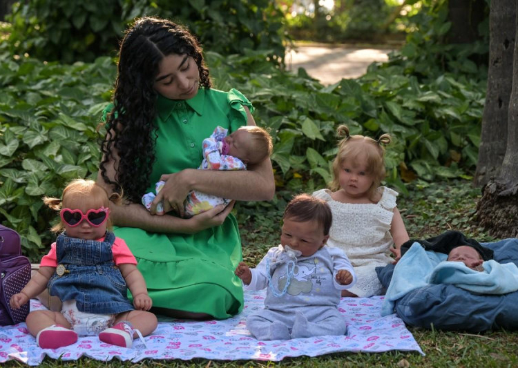 Gabi Matos sosteniendo un "bebé reborn" hiperrealista, representando el fenómeno social que ha generado debate en Brasil.