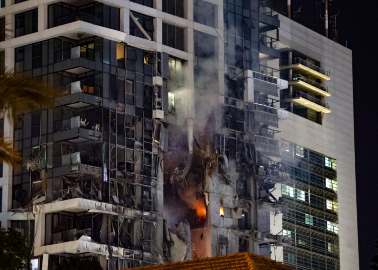 Fire and smoke rise from a building, reportedly hit by a missile fired from Iran, in central Tel Aviv on June 13, 2025. Iran fired a barrage of ballistic missiles at Israel in a counter-strike in the evening on June 13, after an unprecedented onslaught hammered the Islamic republic's top military brass and targeted its nuclear facilities and bases. (Photo by Jack GUEZ / AFP)