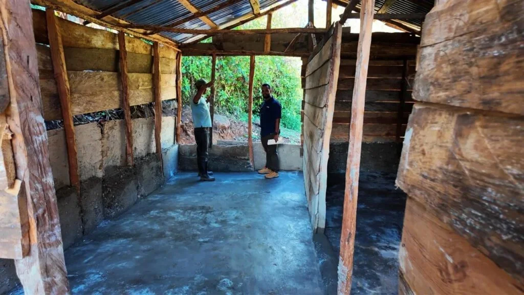 Personal de GoldQuest Dominicana instalando pisos de cemento en una vivienda en San Juan de la Maguana.