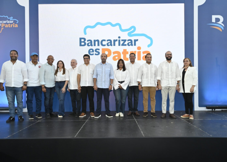 El presidente ejecutivo de Banreservas, Samuel Pereyra, junto al alcalde de Santo Domingo Este, Dio Astacio; el senador de la provincia Santo Domingo, Antonio Taveras Guzmán; Bertico Santana, cónsul general en Paterson, New Jersey; y Benny Metz, presidente de CONADIS, acompañados de varios ejecutivos del Banco, en al jornada de educación financiera celebrada en el Club Deportivo y Cultural de Los Mina.