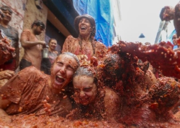 Los participantes se encuentran tumbados en un charco de tomates aplastados durante la fiesta anual de la "Tomatina", en el pueblo de Buñol, cerca de Valencia, España, el miércoles 28 de agosto de 2024.