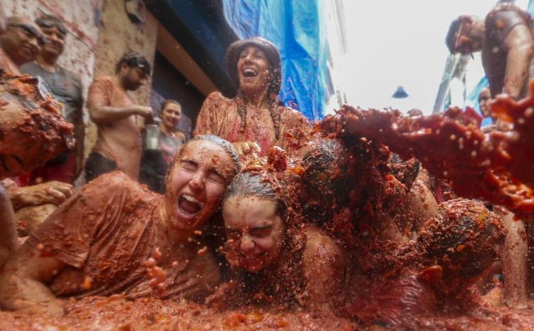 Los participantes se encuentran tumbados en un charco de tomates aplastados durante la fiesta anual de la "Tomatina", en el pueblo de Buñol, cerca de Valencia, España, el miércoles 28 de agosto de 2024.