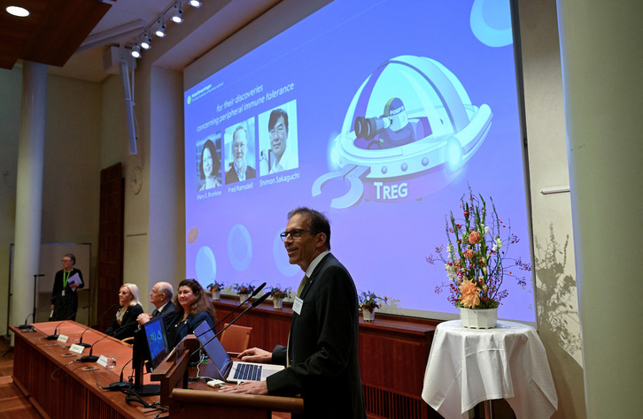 Nobel Committee Secretary General Thomas Perlmann (foreground) addresses journalists in front of a screen displaying the portraits of (L-R) Mary E Brunkow, Fred Ramsdell and Shimon Sakaguchi during a press conference where the winners of the 2025 Nobel Prize in Physiology or Medicine are being announced at the Karolinska Institute in Stockholm, Sweden, on October 6, 2025. Mary E. Brunkow and Fred Ramsdell of the United States and Japan's Shimon Sakaguchi won the Nobel Prize in Medicine on Monday for research into how the immune system is kept in check, the Nobel jury said. (Photo by Jonathan Nackstrand / AFP)