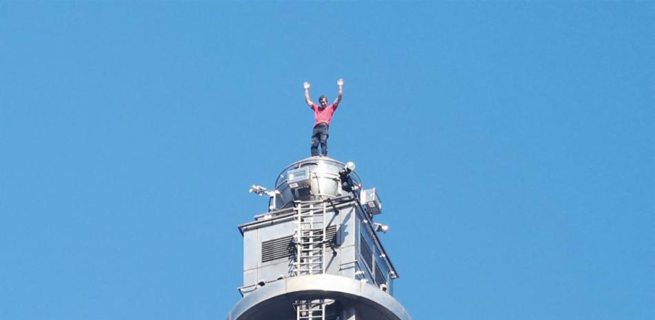 El escalador estadounidense Alex Honnold desde lo alto del edificio Taipei 101 tras escalar con éxito en solo integral el emblemático rascacielos sin cuerdas ni equipo de seguridad en Taipéi.I-HWA CHENG / AF