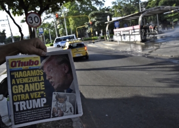 A man shows the front page of a newspaper reading "Make Venezuela great again" and depicting US President Donald Trump and Venezuela's ousted president Nicolas Maduro in Cucuta, Colobia, on the border with Venezuela, on January 4, 2026, a day after a US strike. The government of Colombia announced Saturday that it is preparing to declare an economic state of emergency on the border with Venezuela following the United States attacks in that country and the capture of its president, Nicolas Maduro, in the early hours of the morning. (Photo by Schneyder Mendoza / AFP)