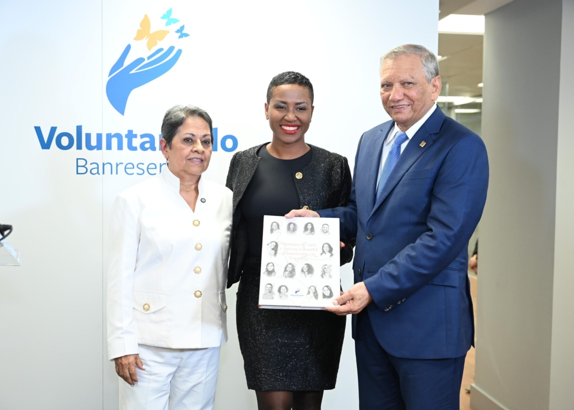 La doctora carmen alicia quijano de aguilera, presidenta del voluntariado banreservas, y el doctor leonardo aguilera, presidente ejecutivo de banreservas, entregan un ejemplar de historias de vida y buena voluntad dominicana en españa a neivy tolentino, una de las dominicanas que narran sus historias en la obra.