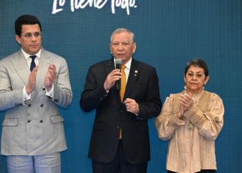 El presidente ejecutivo de Banreservas, doctor Leonardo Aguilera, habla en la feria ANATO 2026. Desde la izquierda, el ministro de Turismo, David Collado; y la presidenta del Voluntariado Banreservas, Carmen Quijano.