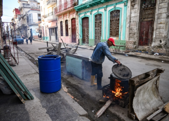 Editors note: graphic content / a man heats water over a wood fire on a street in havana on february 23, 2026. (photo by yamil lage / afp)