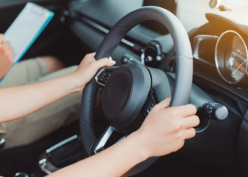 Woman practice driving car exam driver licence control steering wheel education and learn on street road by driving instructor teaching at school drive transportation safety travel, people lifestyle